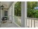 Cozy front porch with white railings, bluestone flooring, ceiling fan and outdoor seating for relaxation at 100 Brookgreen Trace Pl., Pawleys Island, SC 29585