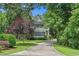 Charming two-story home with lush landscaping, mature trees, and a long driveway leading to the house at 100 Brookgreen Trace Pl., Pawleys Island, SC 29585