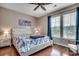 Bright bedroom features a ceiling fan, hardwood floors, and two windows with blue curtains at 100 Culpepper Way # 1002, Myrtle Beach, SC 29579