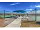 Relaxing covered seating area between community tennis courts with green turf, benches, and shade at 100 Culpepper Way # 1002, Myrtle Beach, SC 29579