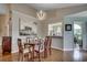 Dining room with hardwood floors, unique light fixture, large painting, and view of kitchen at 1010 Swan Lake Dr., North Myrtle Beach, SC 29582