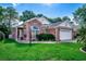 Well-manicured front yard with a brick house, arched windows, and attached garage at 1010 Swan Lake Dr., North Myrtle Beach, SC 29582