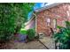 Brick house with a small patio surrounded by greenery, and a gravel pathway at 1010 Swan Lake Dr., North Myrtle Beach, SC 29582