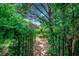 Landscaped walkway through lush garden leading to a brick house with trees at 1010 Swan Lake Dr., North Myrtle Beach, SC 29582
