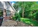 Small brick patio next to green lawn, surrounded by lush greenery and a brick house at 1010 Swan Lake Dr., North Myrtle Beach, SC 29582