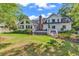 Beautiful back exterior of the home with a spacious deck, lush lawn, and mature trees at 1064 Links Rd., Surfside Beach, SC 29575