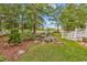 Serene backyard with lush landscaping, stone lanterns, and a white picket fence bordering a golf course at 1064 Links Rd., Surfside Beach, SC 29575
