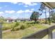 Spacious backyard view with lush green grass, beautiful blue sky, and the community buildings at 1100 Possum Trot Rd. # F218, North Myrtle Beach, SC 29582