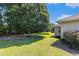 Backyard view showcasing a mature trees, grassy yard, and a house with light siding at 1134 Carleita Circle, Conway, SC 29527