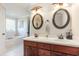 Bathroom featuring double vanity sinks, oval mirrors with lighting, and a view to the tub at 1134 Carleita Circle, Conway, SC 29527