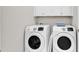 Bright laundry room with front loading washer and dryer and storage cabinets at 1314 Prescott Circle, Myrtle Beach, SC 29577