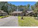 Charming single-story home featuring a well-manicured lawn and inviting curb appeal nestled amongst the trees at 137 Hickory Dr., Conway, SC 29526