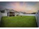 Expansive backyard with lush green lawn, privacy fence, screened porch, and evening sky at 138 Copper Leaf Dr., Myrtle Beach, SC 29588