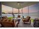 Screened porch offering a cozy seating area with comfortable striped cushions and serene backyard views at 138 Copper Leaf Dr., Myrtle Beach, SC 29588