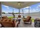 Screened porch offering a cozy seating area with comfortable striped cushions and serene backyard views at 138 Copper Leaf Dr., Myrtle Beach, SC 29588