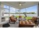 Inviting screened porch featuring comfortable seating, ceiling fan, and serene views of the lush backyard at 138 Copper Leaf Dr., Myrtle Beach, SC 29588