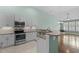 Modern kitchen with stainless steel appliances, granite countertops, tiled backsplash, and light wood floors at 156 Parmelee Dr. # D, Murrells Inlet, SC 29576