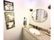 Stylish bathroom vanity with granite countertop, bronze fixtures, oval mirror, and decorative wall art at 160 Comanche Dr., Georgetown, SC 29440