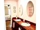 Bathroom featuring double vanity with wood top, oval mirrors, and a view to the connecting bedroom at 160 Comanche Dr., Georgetown, SC 29440