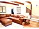 Inviting living room with exposed beams, a brick fireplace, and a comfortable leather couch at 160 Comanche Dr., Georgetown, SC 29440