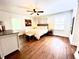 Spacious main bedroom with wood floors, sitting area, and two windows providing natural light at 160 Comanche Dr., Georgetown, SC 29440