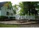 Inviting brick patio with a fire pit, surrounded by a white picket fence and lush greenery at 160 Comanche Dr., Georgetown, SC 29440