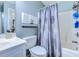 Well-lit bathroom with vanity, toilet, and tub with a leaf-patterned shower curtain at 161 Barclay Dr., Myrtle Beach, SC 29579