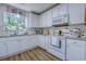 Bright kitchen features white cabinets, modern appliances, granite countertops, and a charming window at 161 Barclay Dr., Myrtle Beach, SC 29579