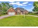 Lovely red brick home featuring a circular driveway and well-maintained lawn and landscaping at 1619 Deer Park Ln., Surfside Beach, SC 29575