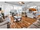 Open-concept living room with hardwood floors, modern furniture, and views into dining area at 1619 Deer Park Ln., Surfside Beach, SC 29575