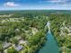 Picturesque aerial view of townhomes near a tranquil river, surrounded by lush trees and neighborhood scenery at 178 Beaver Pond Loop # 60, Pawleys Island, SC 29585