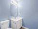 Well-lit bathroom featuring a modern vanity, large mirror, contemporary fixtures, and calming blue walls at 178 Beaver Pond Loop # 60, Pawleys Island, SC 29585
