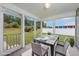 This screened porch features an outdoor dining setup with wicker chairs and a view of the backyard at 219 Blackpepper Loop, Little River, SC 29566
