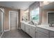 Bright bathroom featuring dual vanities, white cabinetry, and a glass-enclosed shower at 2273 Hazel Way, Longs, SC 29568