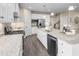 Modern kitchen features white cabinets, stainless steel appliances, granite countertops, and sleek wood flooring at 2273 Hazel Way, Longs, SC 29568