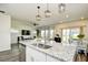 Open concept kitchen and living space featuring a granite countertop island, stainless steel sink and modern hanging lights at 2325 Copper Creek Loop, Longs, SC 29568