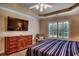 This bedroom features a ceiling fan, plantation shutters, and a dresser at 2450 Marsh Glen Dr. # 112, North Myrtle Beach, SC 29582