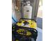 Garage interior view featuring a yellow Champion generator and a white propane tank at 2450 Marsh Glen Dr. # 112, North Myrtle Beach, SC 29582