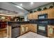 Well-equipped kitchen features wood cabinets, black appliances, and black granite countertops at 2450 Marsh Glen Dr. # 112, North Myrtle Beach, SC 29582