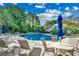 Large community pool with ample seating, umbrellas, and lush landscaping for a resort-style experience at 2450 Marsh Glen Dr. # 112, North Myrtle Beach, SC 29582