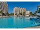 Large outdoor pool surrounded by lounge chairs, palm trees, and resort buildings at 2450 Marsh Glen Dr. # 112, North Myrtle Beach, SC 29582