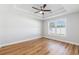 Light-filled bedroom with tray ceiling, ceiling fan, and wood-look floors at 2599 Woodcreek Ln., Conway, SC 29527