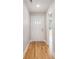 Hallway with hardwood floors leads to a white front door with glass panes and side light at 2599 Woodcreek Ln., Conway, SC 29527