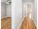 Hallway with hardwood floors leads to a bedroom with ceiling fan and bright lighting at 2599 Woodcreek Ln., Conway, SC 29527