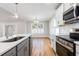 Open kitchen and dining area with stainless steel appliances and wood flooring at 2599 Woodcreek Ln., Conway, SC 29527