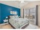 Bedroom with bright blue accent wall, ceiling fan, and large window at 2701 Kashton Dr., Myrtle Beach, SC 29577