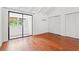 Bedroom with hardwood floors, sliding door, closet, and white walls with a window providing natural light at 310 74Th Ave. N # 7, Myrtle Beach, SC 29572
