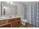 A well-lit bathroom features wood-paneled vanity, a large mirror, and a shower with a patterned curtain at 311 Ashwood Ln., Myrtle Beach, SC 29588