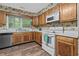 Functional kitchen featuring oak cabinets, white appliances, and a window overlooking the yard at 311 Ashwood Ln., Myrtle Beach, SC 29588