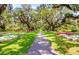 Enchanting garden path framed by moss-draped trees, vibrant flowers, and manicured lawns at 3154 Shorecrest Bay Dr., Murrells Inlet, SC 29576